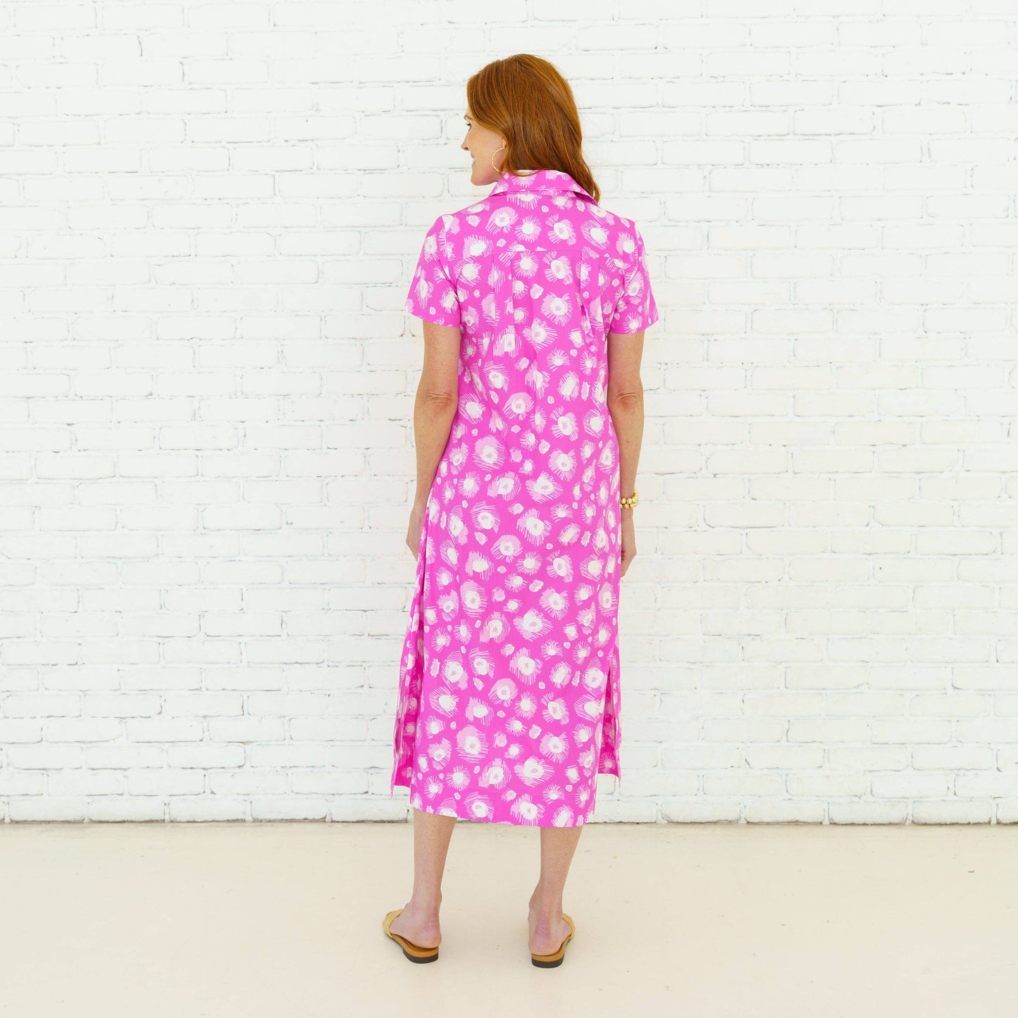 Pink Millie Burst Midi Dress by Caryn Lawn, featuring a flowy silhouette and vibrant floral pattern, shown on a model.