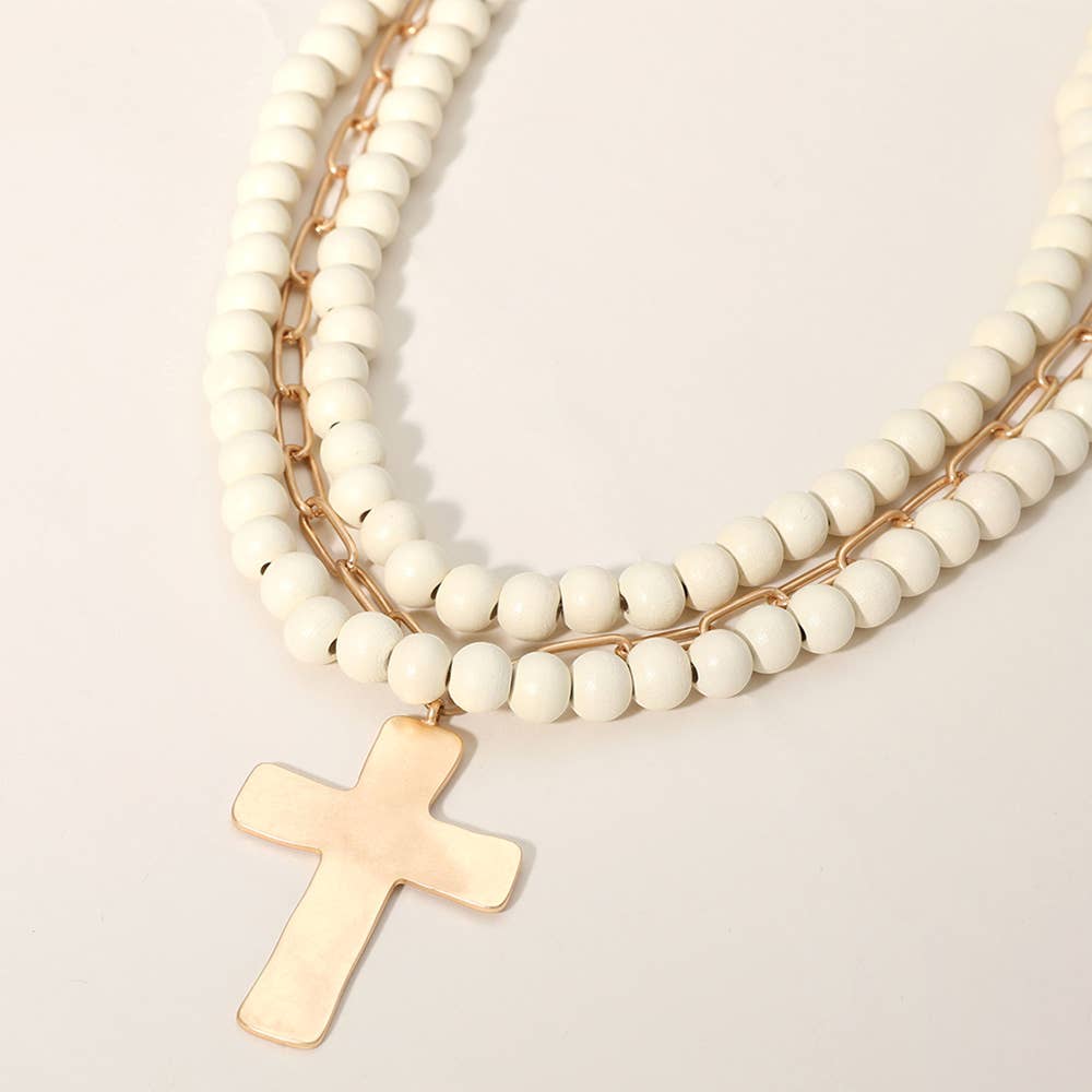 Hammered metal cross pendant with wood beads on a Sensibling Corp. jewelry necklace, featuring a stylish and handcrafted design.