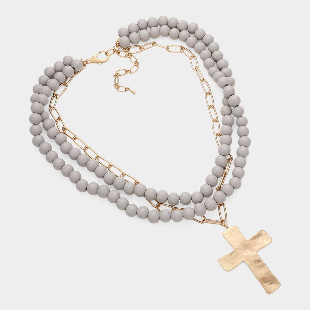 Hammered metal cross pendant necklace with wood beads, jewelry piece featuring a religious cross from Sensibling Corp.