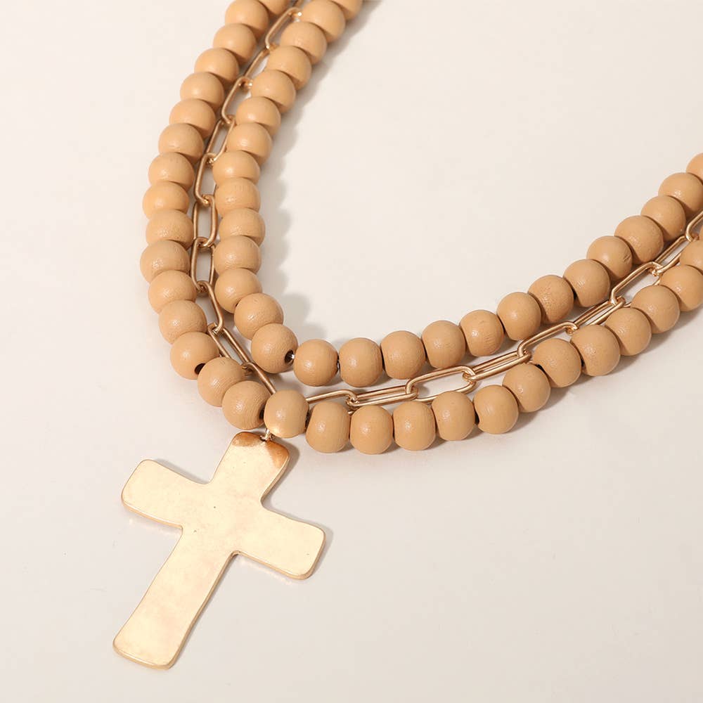 Hammered metal cross pendant necklace with wood beads, jewelry piece by Sensibling Corp. featuring a detailed cross and beaded design.