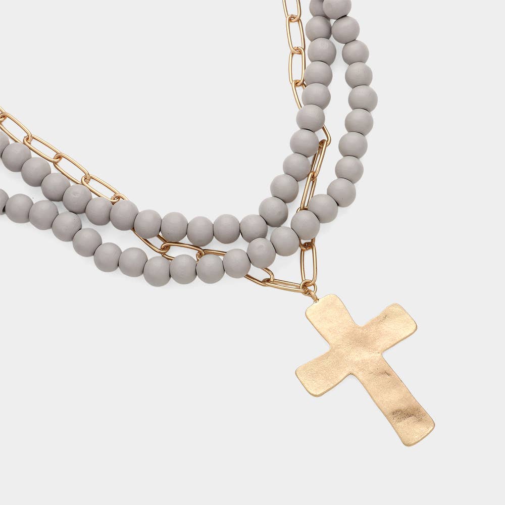 Hammered metal cross pendant with wood bead necklace, jewelry by Sensibling Corp., featuring a rustic cross design and natural beads.