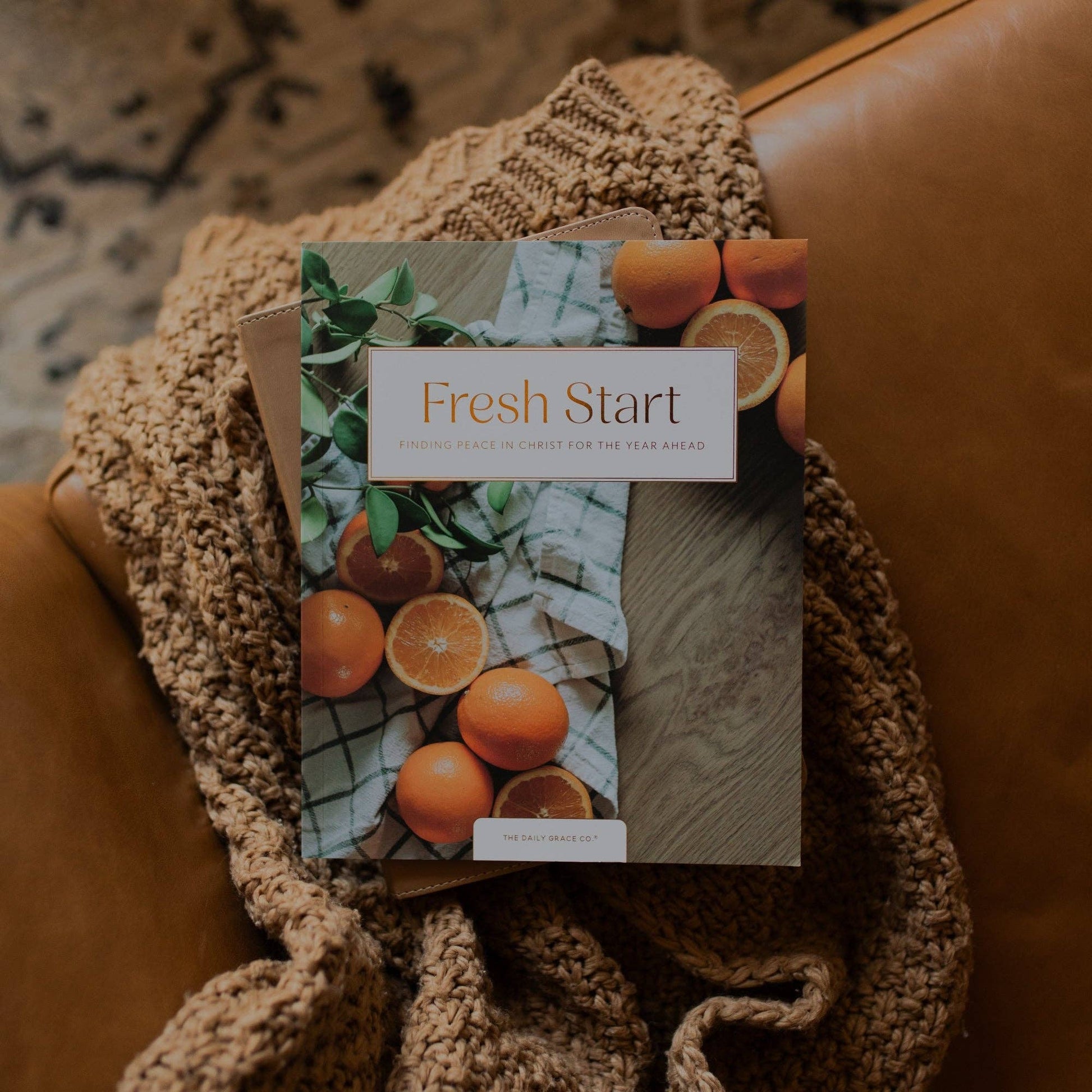 Open devotional book titled Fresh Start Devotional by The Daily Grace Co featuring inspirational quotes and Bible verses.