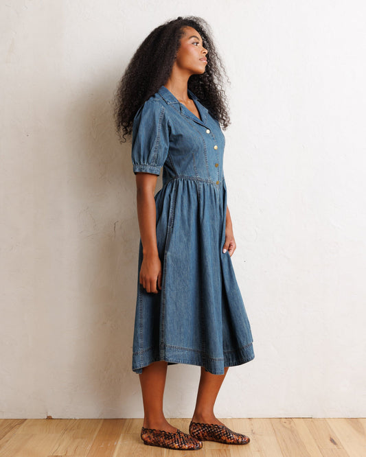 Downeast Orchard Denim Dress hanging on a rustic wooden hanger, showcasing casual style and classic denim fabric.
