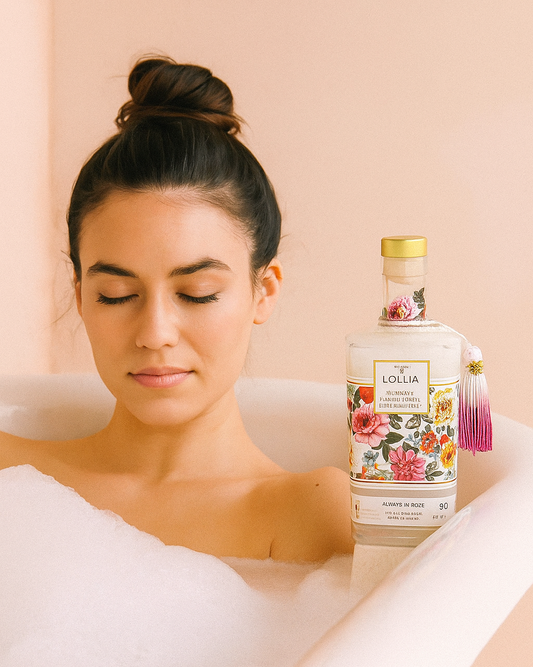 Woman in a bathtub with a bottle of Lollia product on a peach background