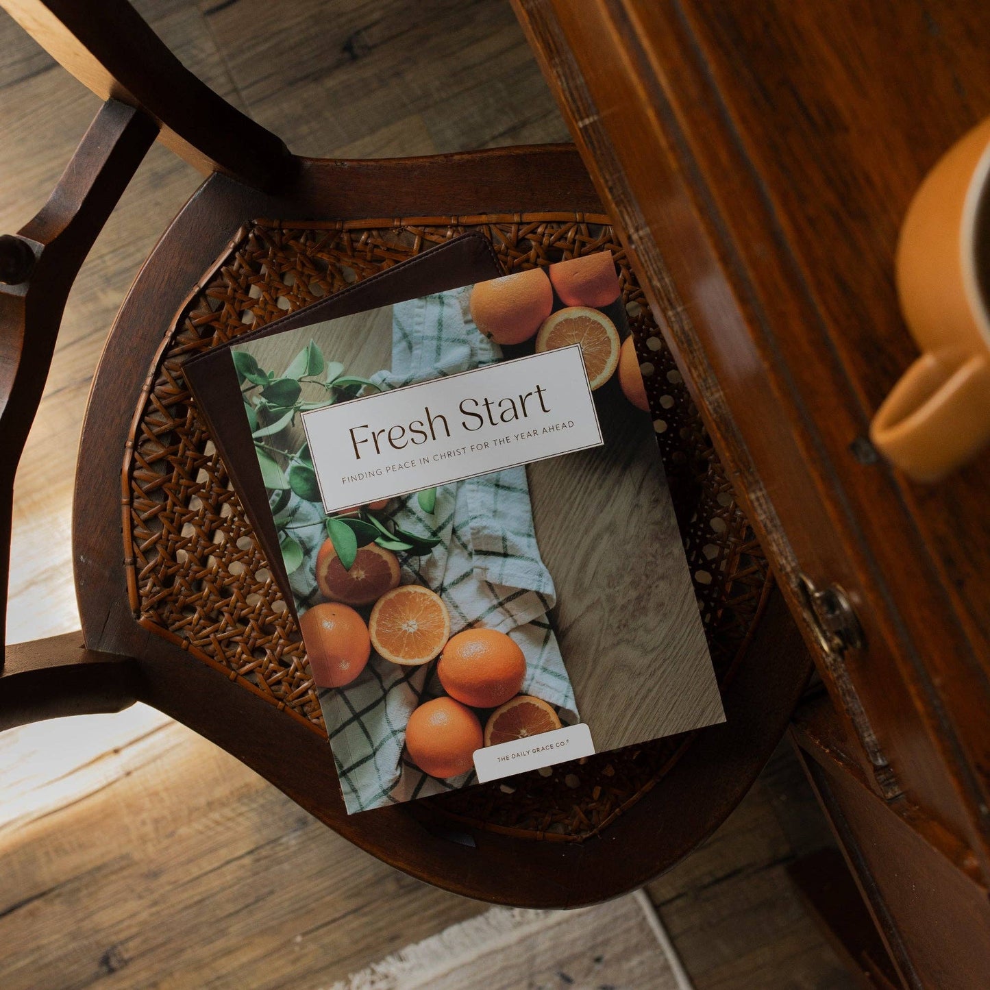 Open devotional book titled "Fresh Start Devotional" by The Daily Grace Co with pages displayed on a table.