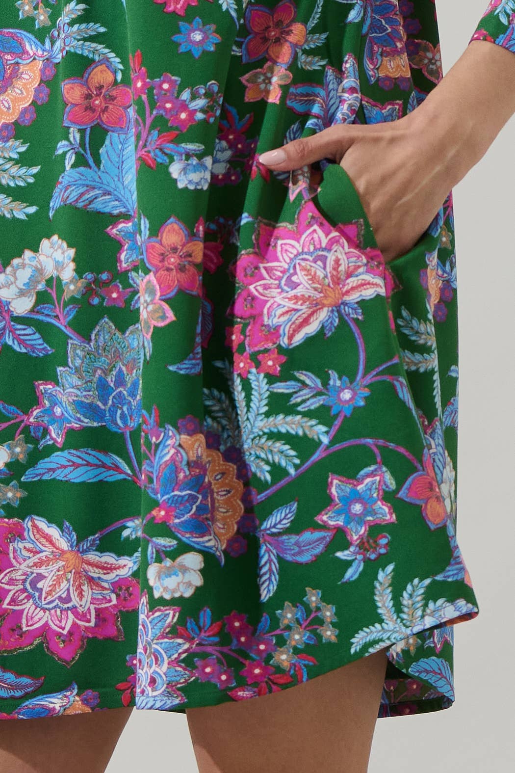 Sugarlips Elara Emerald Ruelle Mini Dress displayed on hanger with intricate details and vibrant emerald color.
