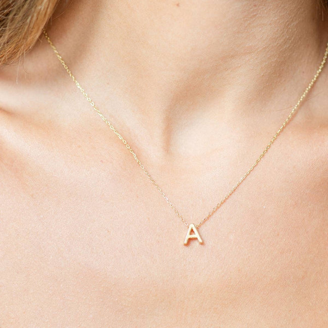 Gold initial necklace from Splendid Iris featuring a personalized pendant on a delicate chain.