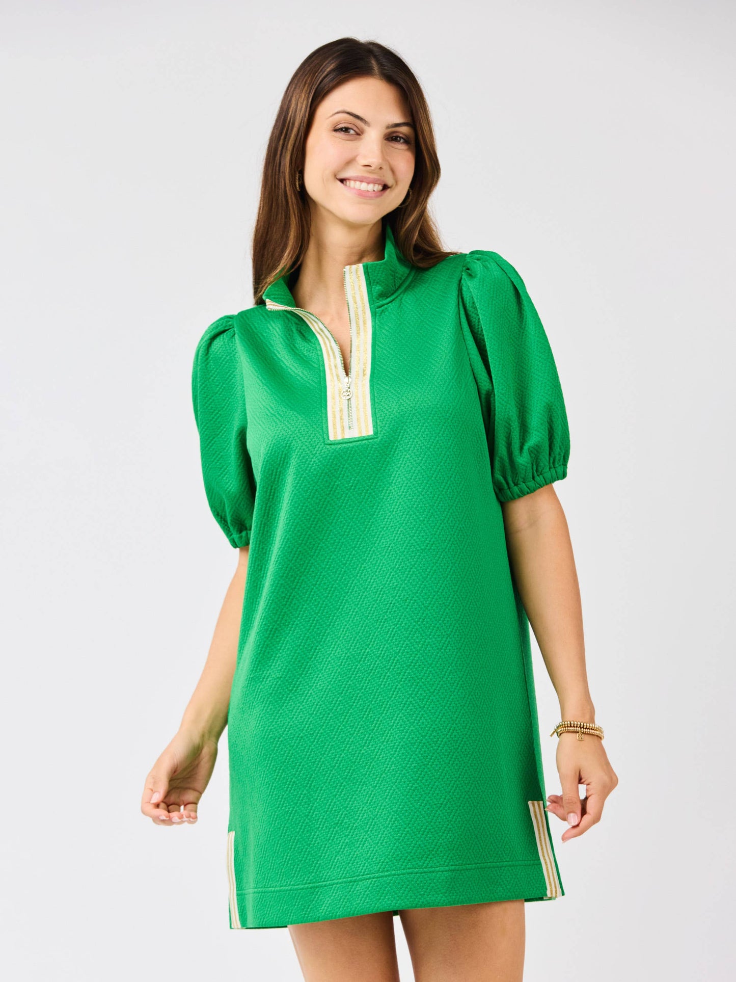 Mary Square Andie Emerald Statement Dress hanging on a wooden hanger, showcasing its vibrant color and elegant design.