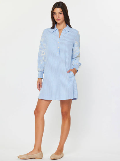 Current Air Eloise Embroidered Misty Blue Dress with floral embroidery and flowing fabric, displayed on a hanger.