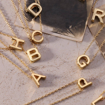 Gold initial necklace with a sleek pendant featuring a personalized letter, crafted by Splendid Iris jewelry brand.