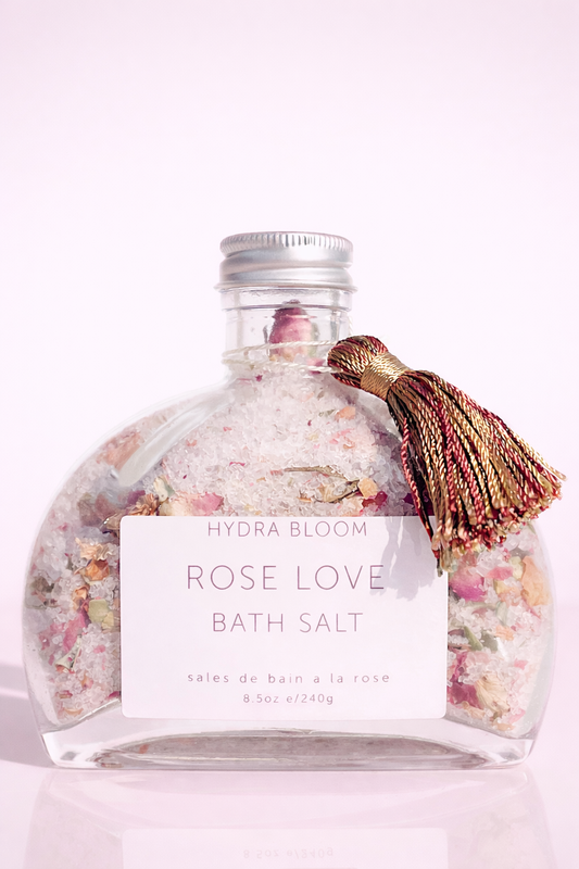 Pink and white rose-shaped luxury bath salts in a clear glass jar with Hydra Bloom Beauty label for a relaxing home spa experience.
