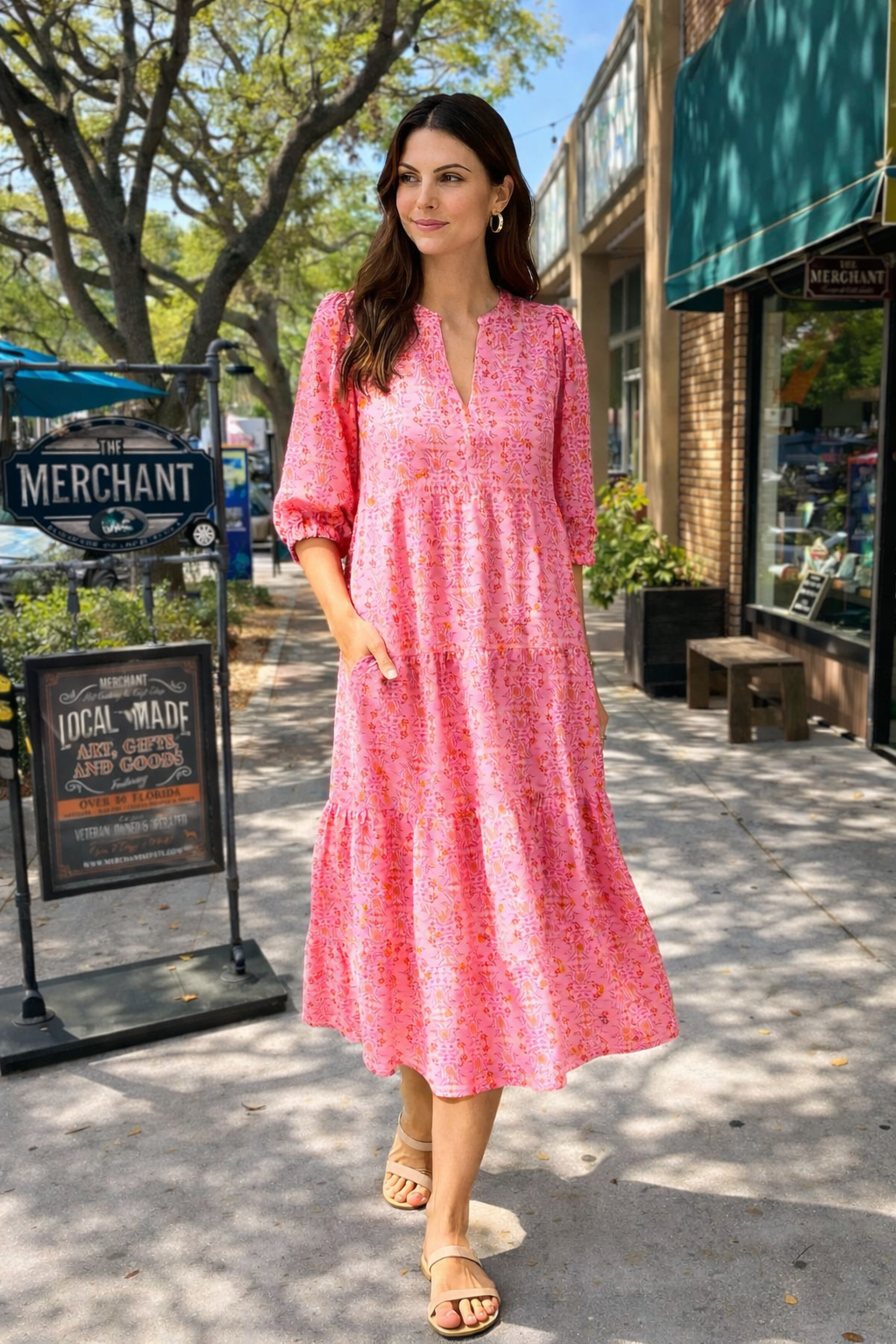 Woman wearing the Cameron Dress in Heirloom Vine Pink by Mary Square, standing on a sunny sidewalk.