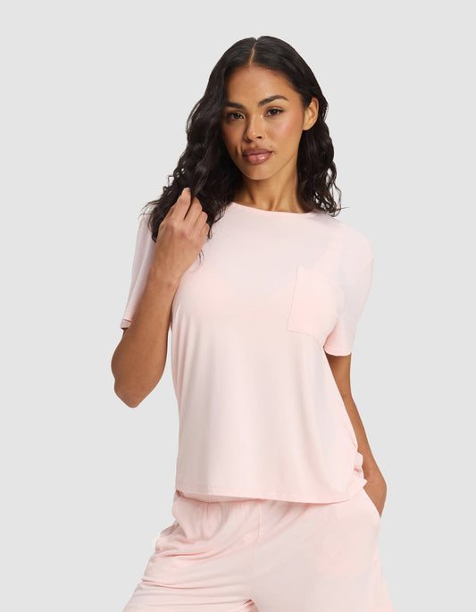 Women's bamboo stretch-knit lounge tee and pants set by Cozy Earth, featuring a soft blossom-colored top and matching relaxed pants.
