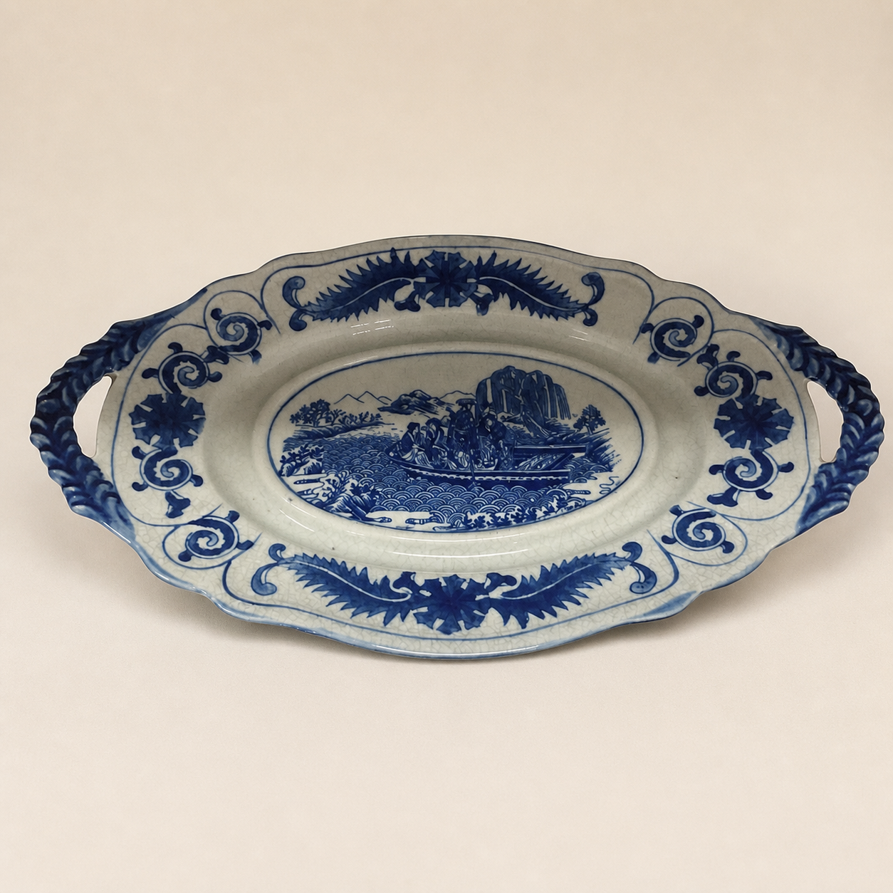 Blue and white boat scene decorative tray on an ivory studio background