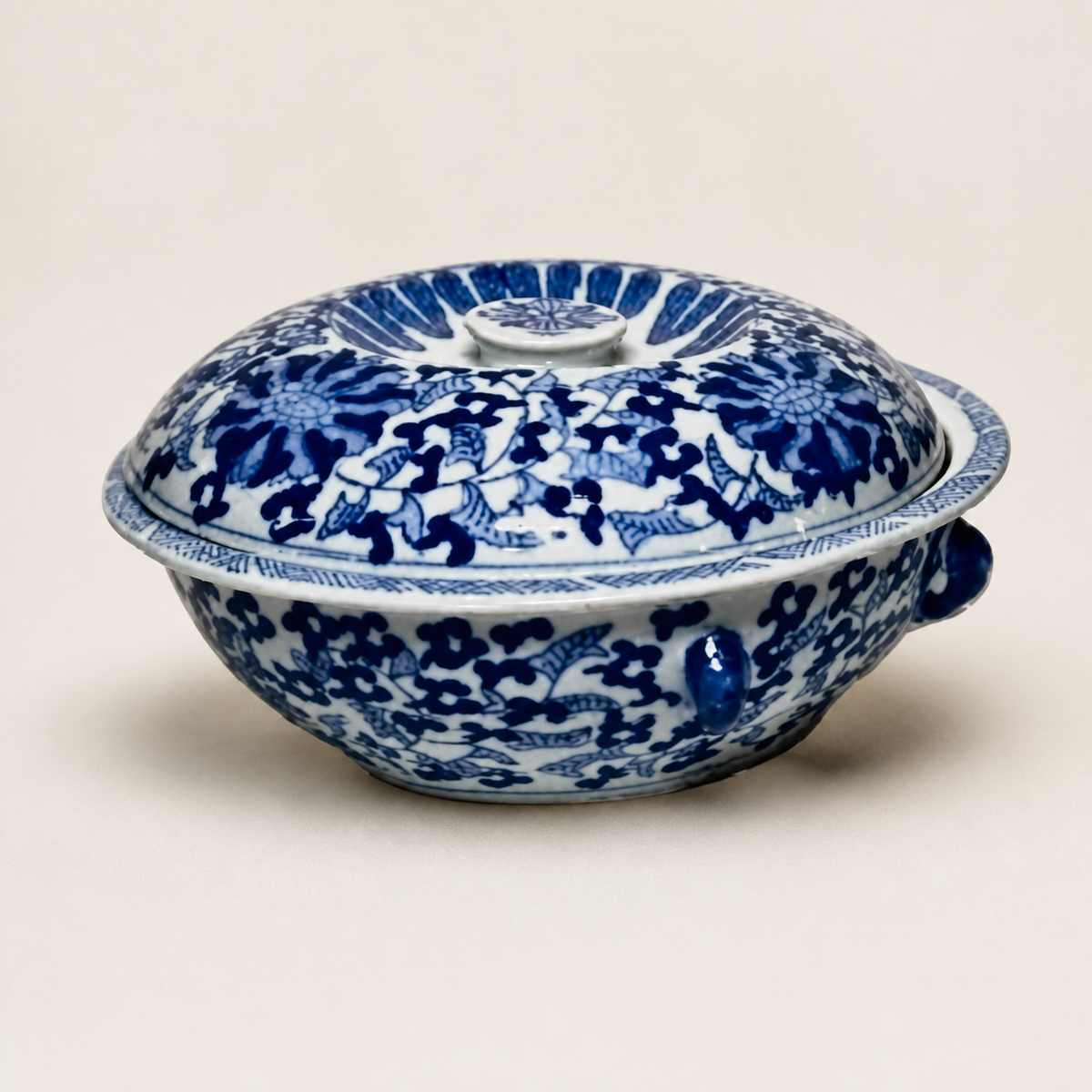 Blue and white lotus scroll covered tureen on an ivory studio background