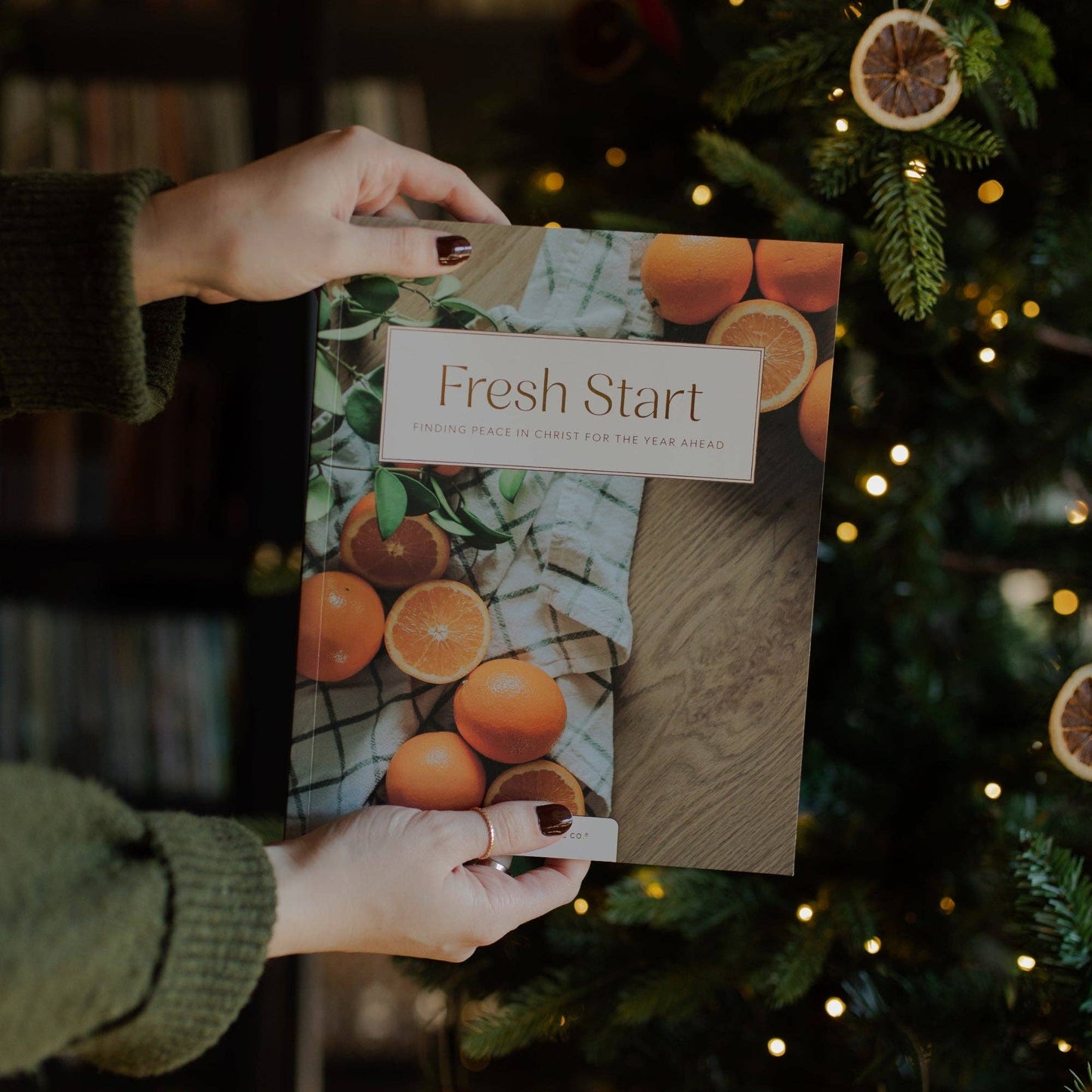Open devotional book titled "Fresh Start Devotional" by The Daily Grace Co, featuring inspirational pages and a soft, inviting cover.