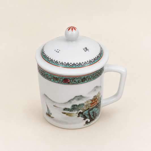 Jingdezhen landscape lidded tea mug on an ivory studio background