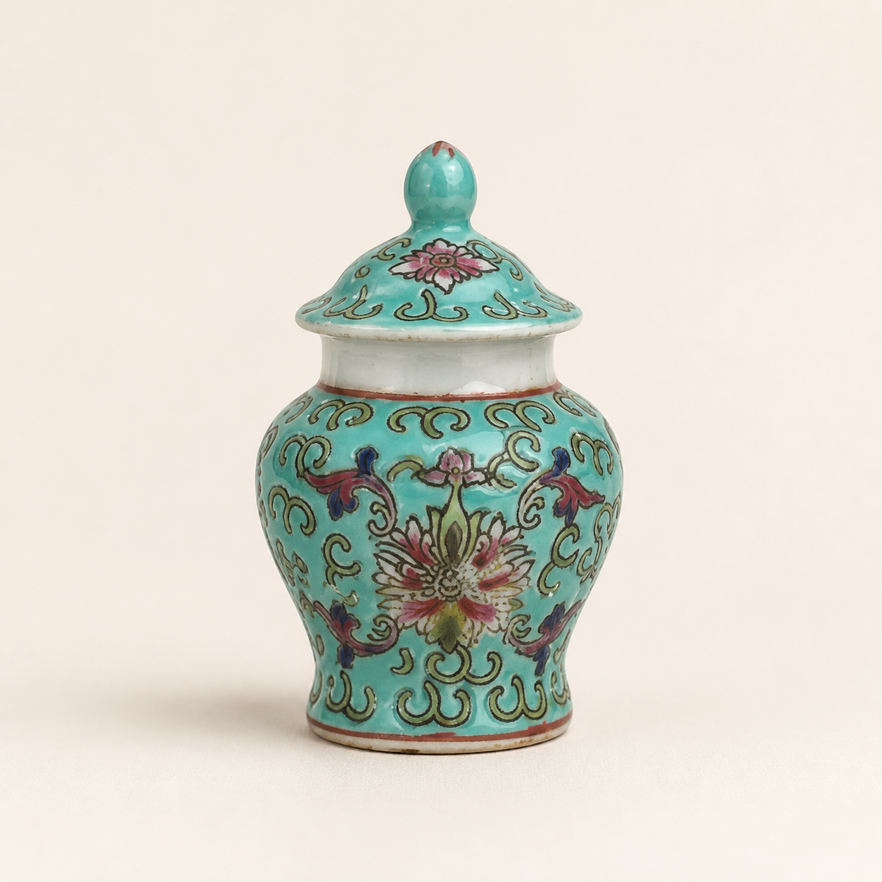 Miniature turquoise ginger jar on an ivory studio background