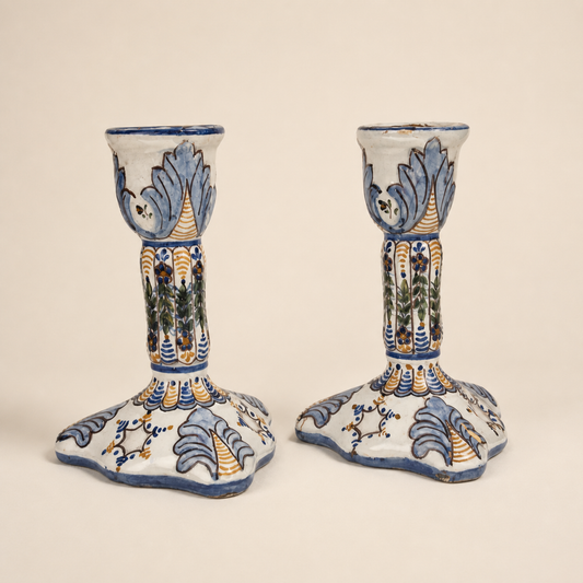 Pair of Portuguese faience candlesticks in as-is repaired condition on an ivory studio background