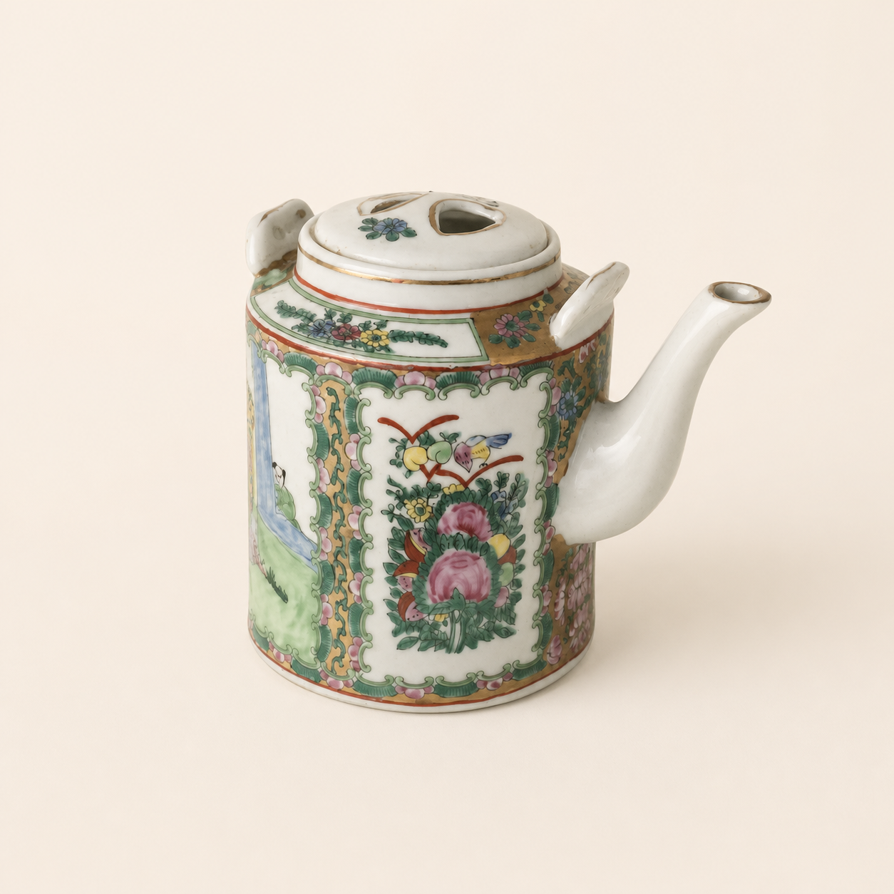 Rose Medallion teapot with missing handle strap on an ivory studio background