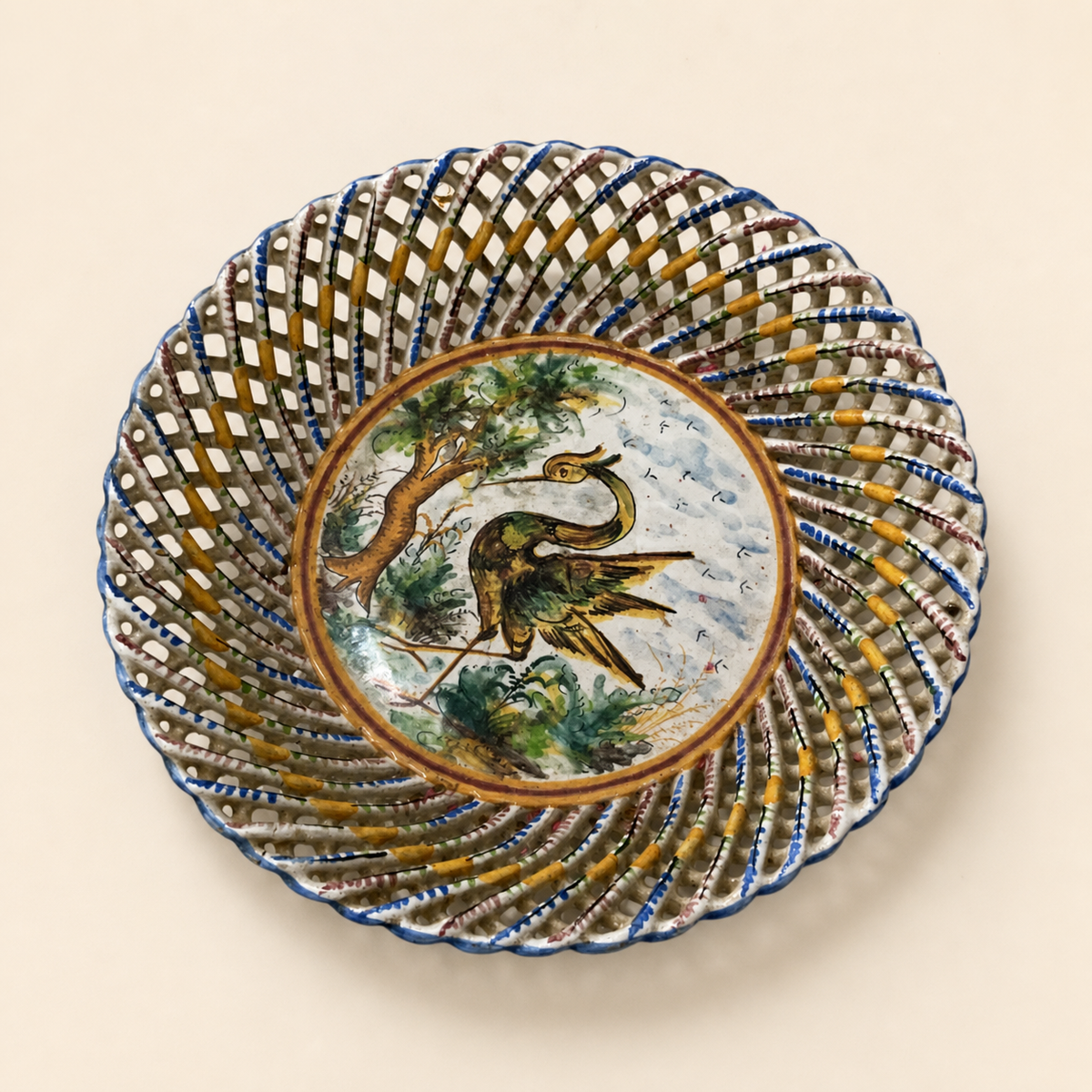 Spanish reticulated Talavera-style heron plate on an ivory studio background
